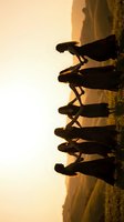 Group of five people holding hands in silhouette against golden sunset sky creating unity and friendship concept for teamwork and connection themes.