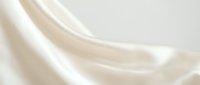 Luxurious cream silk fabric with elegant flowing folds and soft draping texture for premium fashion design and sophisticated interior decor projects.