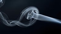 Elegant white smoke swirls rising gracefully against dark background creating abstract flowing patterns for artistic design projects.