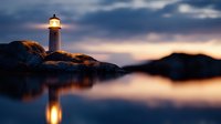 Lighthouse beacon illuminating rocky coastline at twilight with dramatic sky and calm water reflection creating serene maritime landscape for navigation safety.