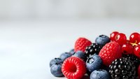 Fresh mixed berries including strawberries, blueberries, raspberries and blackberries on white background for healthy eating and nutrition concepts.