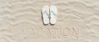White flip flops on sandy beach with vacation text carved in sand, summer holiday travel concept, tropical getaway banner background.