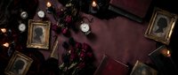Dark vintage flat lay with antique portrait photographs, dried roses, pocket watches and candles on burgundy velvet background for gothic design projects.