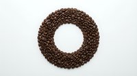 Coffee beans arranged in circular wreath shape on white background, isolated for design use in cafes, restaurants and beverage marketing materials.