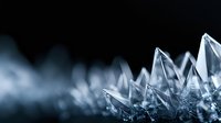 Macro shot of natural crystal formation with sharp geometric peaks against dark background, creating dramatic contrast and depth in cool blue tones.