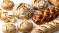 Assorted fresh artisan bread loaves and rolls with golden crusts displayed on white background for bakery and food design projects.