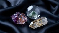 Collection of healing crystals and gemstones on dark silk fabric for meditation, spiritual wellness, and alternative therapy practices.