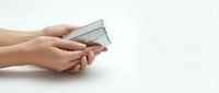 Female hands holding modern smartphone with blank white screen on clean white surface for mockup and app presentation purposes.