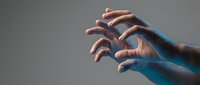 Male hands reaching forward with dramatic blue and orange lighting effects creating artistic shadows and highlights on neutral background.