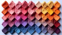 Colorful crushed makeup powder samples arranged in geometric pattern showing gradient transition from orange and pink to blue and purple tones on light background.