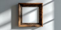 Empty rustic wooden picture frame on white wall with natural shadow patterns, perfect for interior design mockups.