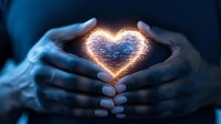 Glowing heart shape formed by magical light between cupped hands in dark blue atmosphere, creating mystical romantic mood for valentines and love concepts.