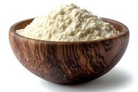Fresh wheat flour in rustic wooden bowl with natural grain pattern, isolated on white background for food photography and packaging design.