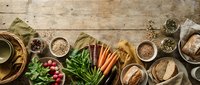 Healthy organic ingredients arranged on rustic wooden table including fresh vegetables, herbs, grains and natural cooking elements for nutritious meal preparation.