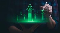 Businessman hand touching holographic green growth chart with upward arrows on tablet screen showing financial success and data analytics.