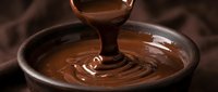 Melted chocolate pouring into bowl creating smooth swirl pattern, ideal for confectionery, dessert, and food industry marketing materials.