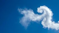 Dramatic spiral cloud formation against vibrant blue sky creating natural swirl pattern for weather concepts and atmospheric phenomena backgrounds.