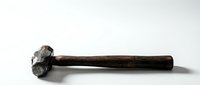 Vintage wooden hammer with metal head isolated on white background for carpentry woodworking construction and craft projects.