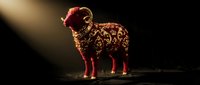 Golden ornate sheep sculpture with intricate floral patterns standing in dramatic spotlight against dark background for luxury decor and artistic displays.