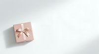 Wrapped gift box with rose gold ribbon bow on white background, isolated for holiday, celebration, and design projects.