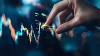 Finger touching financial chart on digital display with stock market data analysis, trading graph showing price movements and candlestick patterns in blue tones.