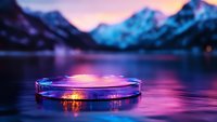 Transparent glass platform floating on serene mountain lake at sunset with purple and pink sky reflections creating magical atmosphere for product display.
