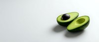 Fresh ripe avocado halves with pit on clean white background, healthy organic fruit for cooking, nutrition and diet concepts.
