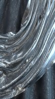 Shimmering metallic fabric with silver and charcoal striped texture, featuring sparkly embellishments and flowing draped folds for fashion, textile, and design projects.
