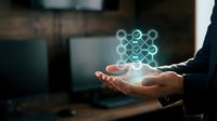 Businessman holding glowing network connection hologram in palm representing digital connectivity and data transfer in modern office environment.