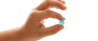 Close-up of hand holding small blue sphere isolated on white background, suitable for business, technology, and design projects.