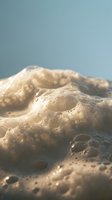 Fresh bread dough with bubbles and texture on soft blue background for baking and culinary projects.