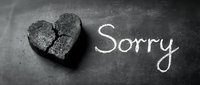Broken stone heart and handwritten Sorry text on dark chalkboard, expressing regret, apology, and emotional pain in monochrome style.