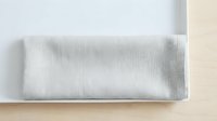 Light gray linen fabric roll displayed on neutral background, showcasing textile texture and weave pattern for interior design and home decor projects.
