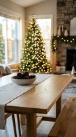 Cozy Christmas living room with illuminated tree, wooden dining table with pinecone bowl, stone fireplace and warm holiday lighting creating festive atmosphere.