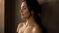Young woman with closed eyes in warm golden sunlight creating peaceful meditation moment with soft shadows and serene expression for wellness content.