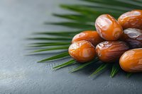 Fresh dates arranged on palm leaves creating natural organic food composition for healthy eating and Middle Eastern cuisine concepts.