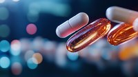 Glowing amber medical capsules floating against blurred blue bokeh background, showcasing pharmaceutical innovation and healthcare advancement.