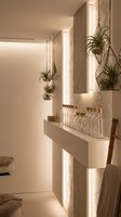 Modern minimalist interior with floating wooden shelves, hanging air plants in geometric terrariums, and warm LED lighting creating cozy ambiance for home decor.