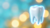 White tooth with protective blue glow against soft bokeh background for dental health and oral care concepts.