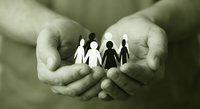 Protective hands holding paper cutout family figures representing care, support, insurance and community unity in sepia tone.