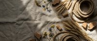 Vintage nautical rope with cork stoppers and maritime accessories on linen fabric background for coastal home decor and sailing themed designs.