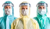 Medical workers wearing protective equipment, face shields, and surgical masks in turquoise and yellow hazmat suits standing together for healthcare safety.