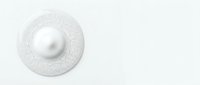 Isolated white pearl resting on decorative circular textured plate against neutral background, suitable for luxury jewelry, cosmetics, and design projects.