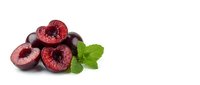 Fresh ripe plums cut in half showing red flesh and pits with green mint leaves isolated on white background for healthy food and nutrition concepts.