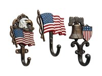 Patriotic cast iron wall hooks featuring eagle, flag, and liberty bell designs with American flag accents. Vintage-style decorative hooks for entryways, offices, and themed decor.