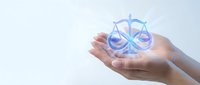 Hands holding glowing scales of justice symbol representing legal services, law firm consultation, attorney advice, and judicial balance concepts.