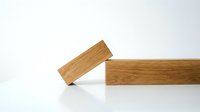 Wooden building blocks stacked on white surface showing natural wood grain texture for educational toys and construction play activities.