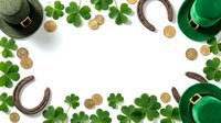 Overhead view of St. Patrick's Day decorations with green hats, horseshoes, gold coins and shamrock leaves arranged on white background for holiday celebrations.
