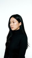 Young Asian woman in black turtleneck sweater looking away thoughtfully on white background for professional headshot and portrait photography.