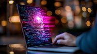 Programming code on laptop screen glowing with vibrant pink and purple colors against dark background, hands typing on keyboard with blurred bokeh lights.
